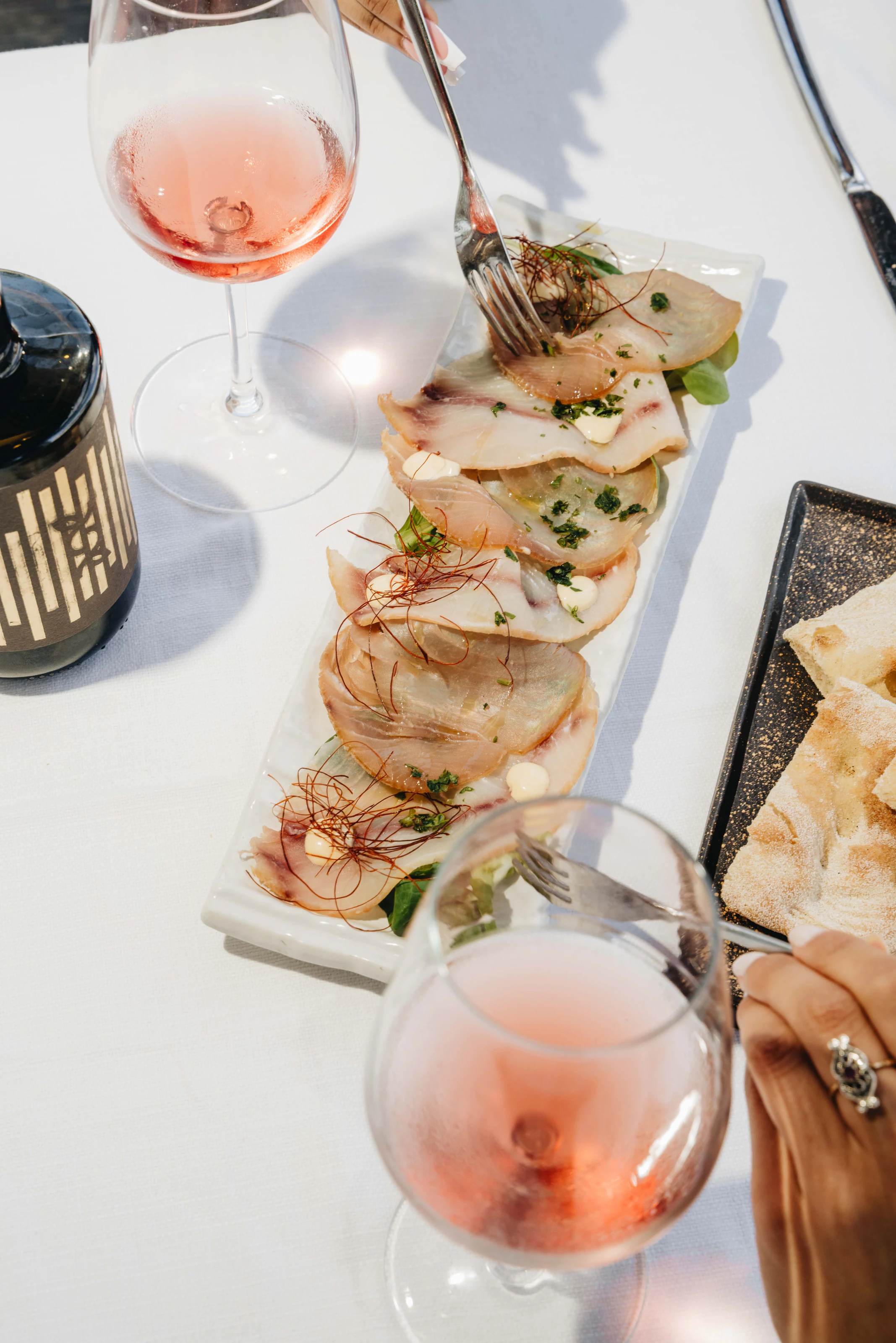Crudo con calici rosati sul tavolo
